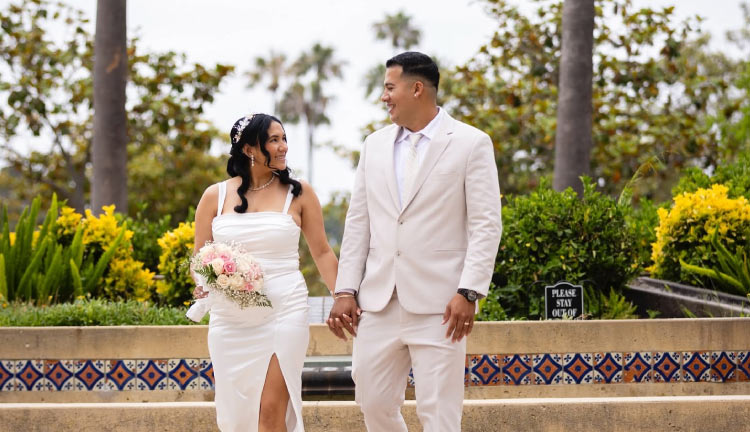 Bride and groom in matching cream outfits walking hand in hand through a garden, Ventura County wedding photography