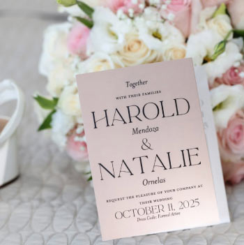 Wedding invitation card for Harold and Natalie surrounded by pink and white floral bouquet