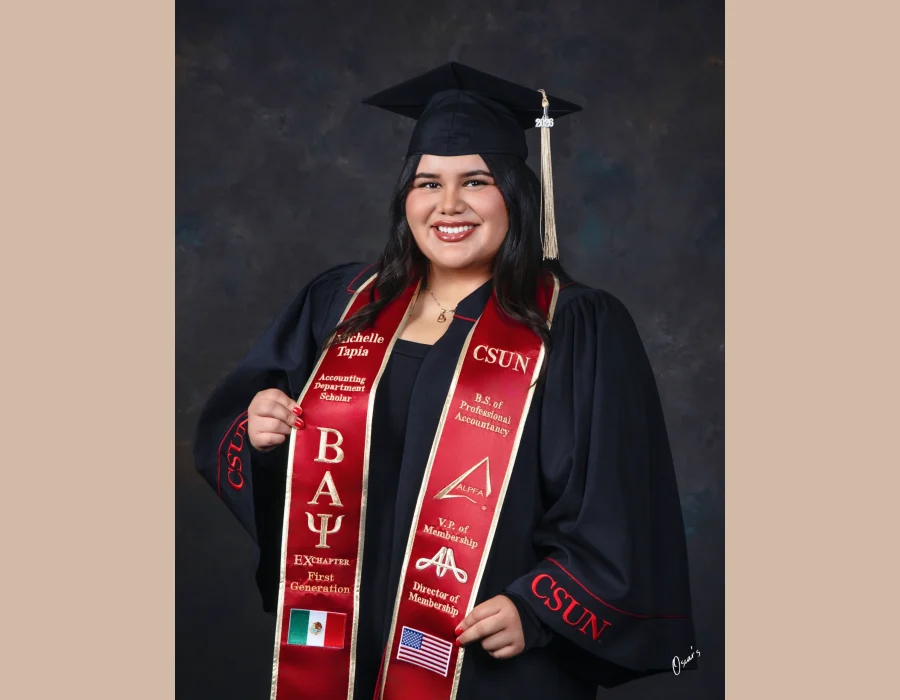 University graduate in a black CSUN gown and a red embroidered stole reading "Accounting Department Scholar," "First Generation," and "B.S. of Professional Accountancy," with Mexican and American flag patches.