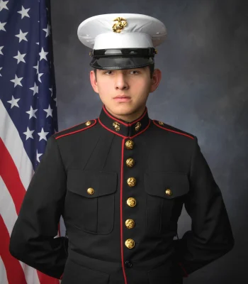 Graduation portrait of a young man in Marine Corps dress uniform with white cap, studio backdrop