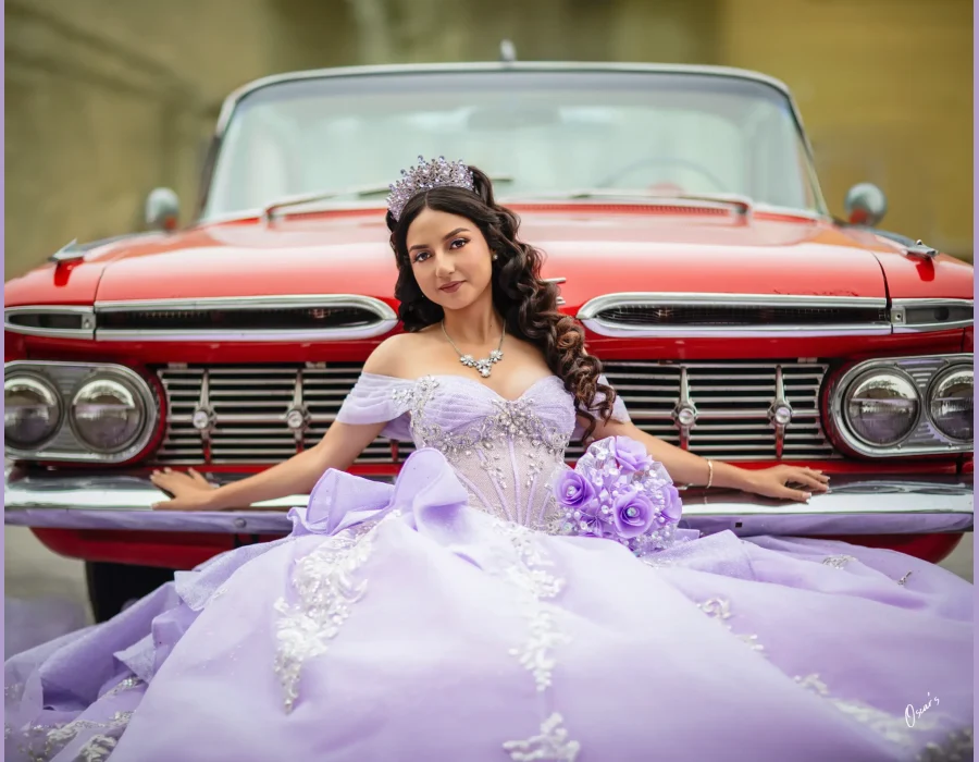 Quinceañera portrait in a lavender beaded gown with a crystal tiara, posing against a vintage red convertible