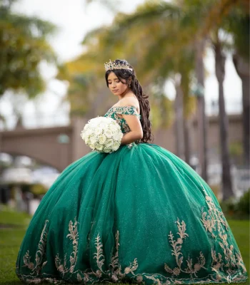 Quinceañera profile portrait in a sage green floral gown, holding a white rose bouquet on a grassy lawn