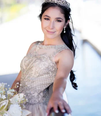 Quinceañera group portrait in a light blue sequined gown, posing with a large court of friends in matching light blue and gray outfits