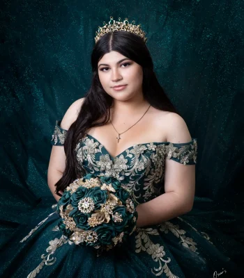 Quinceañera portrait in a pale blue beaded gown, standing in the aisle of a church with a glowing golden altar behind her