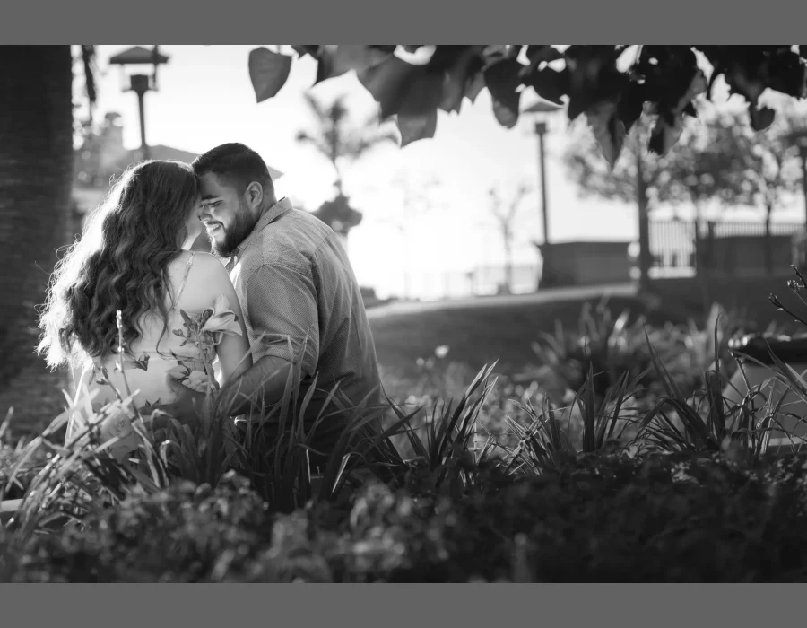 Wedding couple embracing in a garden setting (black and white) — couple nose to nose among greenery