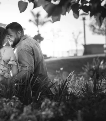Wedding couple embracing in a garden setting (black and white) — couple nose to nose among greenery
